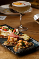 Bruschettas with vegetables. Start dishes with cherry tomatoes, avocado, cream cheese and shrimps. Food composition, tasty italian meal