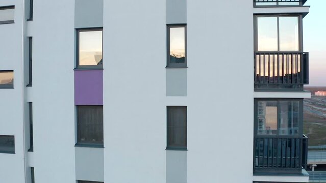 Top view of modern residential building with windows. Stock footage. Vertical panning of residential building with windows. Reflection of sky in windows of residential building