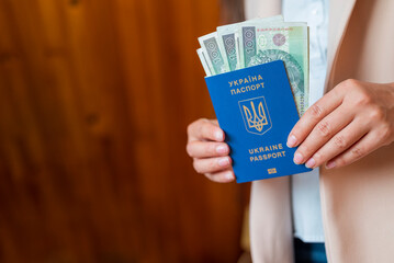 a girl holds in her hands a Ukrainian biometric passport with Poland zloty banknotes - obrazy, fototapety, plakaty