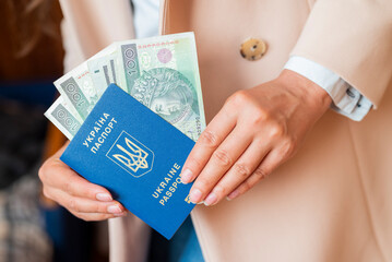 a girl holds in her hands a Ukrainian biometric passport with Poland zloty banknotes