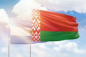Sunny blue sky and flags of belarus and argentina