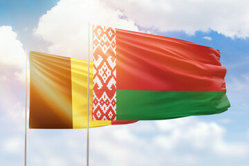 Sunny blue sky and flags of belarus and belgium