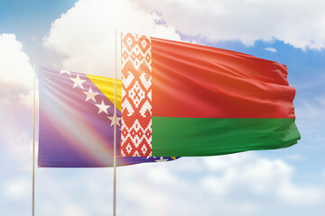 Sunny blue sky and flags of belarus and bosnia