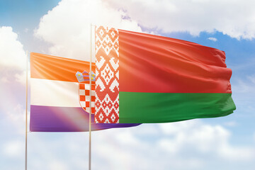 Sunny blue sky and flags of belarus and croatia