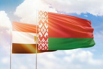 Sunny blue sky and flags of belarus and egypt