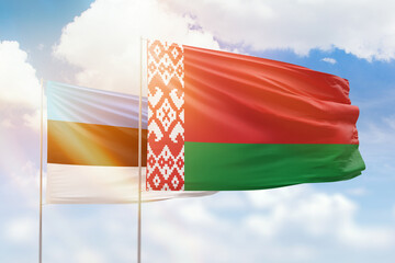 Sunny blue sky and flags of belarus and estonia