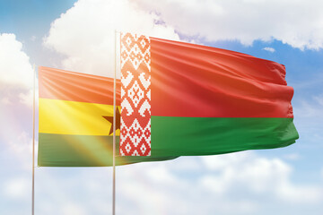 Sunny blue sky and flags of belarus and ghana
