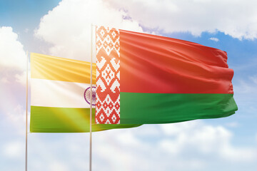 Sunny blue sky and flags of belarus and india