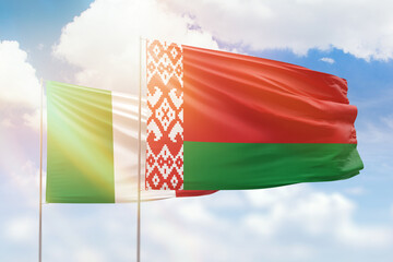 Sunny blue sky and flags of belarus and italy