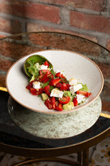 Tasty and healthy salad with arugula, brie cheese, avocado, cherry tomatoes and strawberry. Top view. The flat lay. Banner
