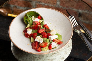 Tasty and healthy salad with arugula, brie cheese, avocado, cherry tomatoes and strawberry. Top view. The flat lay. Banner