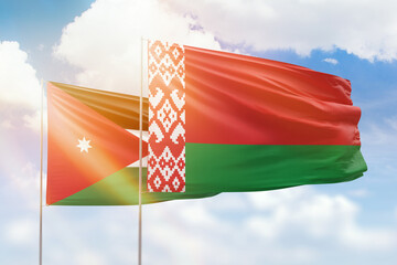 Sunny blue sky and flags of belarus and jordan