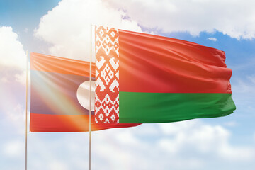 Sunny blue sky and flags of belarus and laos