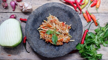 Sambal mangga, is spicy shredded green mango salad served in mortar plate 