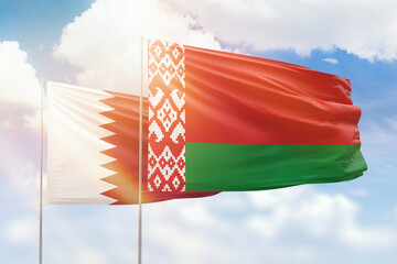 Sunny blue sky and flags of belarus and qatar