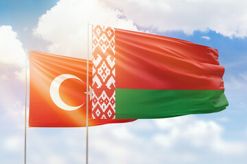 Sunny blue sky and flags of belarus and turkey