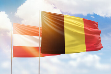 Sunny blue sky and flags of belgium and austria