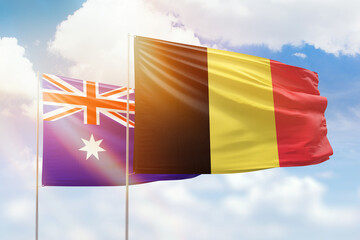 Sunny blue sky and flags of belgium and australia