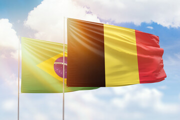 Sunny blue sky and flags of belgium and brazil