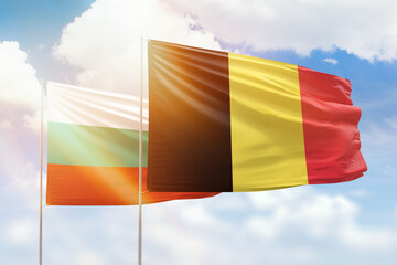 Sunny blue sky and flags of belgium and bulgaria