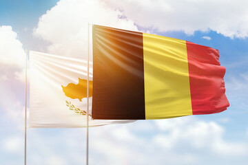 Sunny blue sky and flags of belgium and cyprus