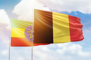 Sunny blue sky and flags of belgium and ethiopia