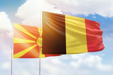 Sunny blue sky and flags of belgium and north macedonia