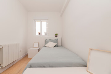 Fototapeta na wymiar Bedroom with single bed with blue bedspread, white aluminum radiator and sliding door window
