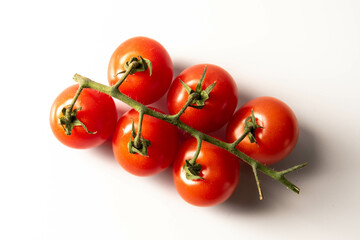 Fresh red tomatoes with green stems isolated on white background. top view.