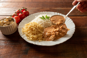 Chicken stroganoff accompanied with rice, salad and potato straw.