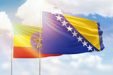 Sunny blue sky and flags of bosnia and ethiopia