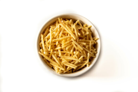 Potato straw or potato straw in a bowl isolated over white background. top view