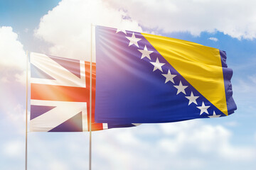 Sunny blue sky and flags of bosnia and great britain