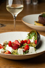 Tasty and healthy salad with arugula, brie cheese, avocado, cherry tomatoes and strawberry. Top view. The flat lay. Banner