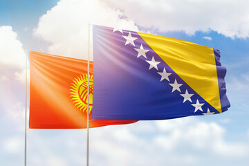 Sunny blue sky and flags of bosnia and kyrgyzstan