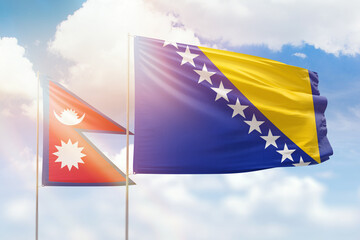 Sunny blue sky and flags of bosnia and nepal
