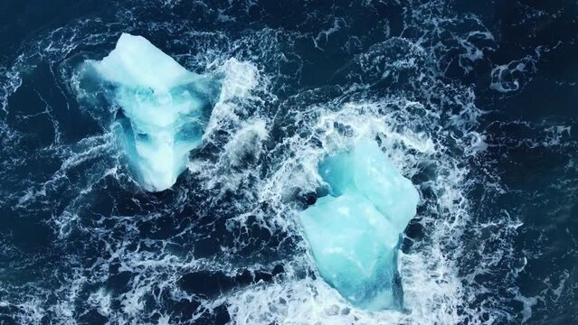 Iceberg in the ocean, Huge Chunks of Blue Ice floating on the waves, Arctic landscape aerial view, clean water, global warming and climate change concept