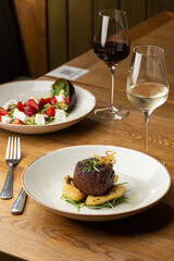 Grilled meat fillet steak medallion with green sauce, served with pear or apple. On dark background