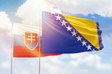Sunny blue sky and flags of bosnia and slovakia
