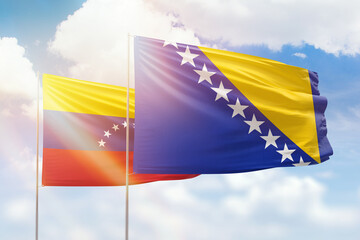 Sunny blue sky and flags of bosnia and venezuela