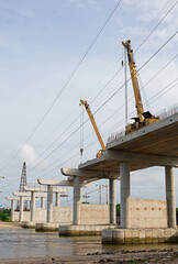 Cranes are working on building a bridge across the canal.