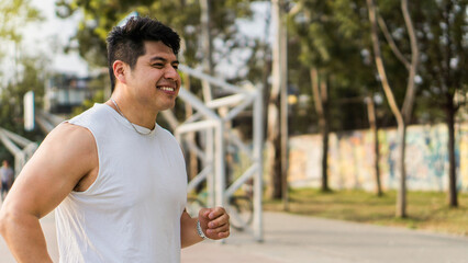 Portrait of a handsome and muscular man running, he is athletic and is in a city neighborhood.	