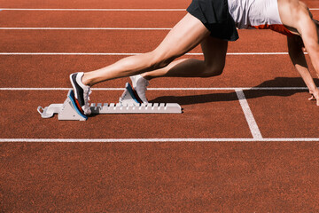 Un coureur au départ sur une piste de stade d'athlétisme