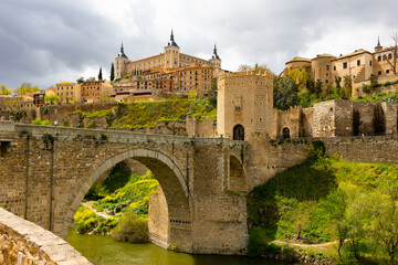 Picturesque view of Alcazar fortress and Alcantara bridge over Tagus river at old Spanish town of...