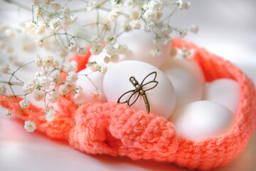 Spring Easter  still life. Chicken white eggs in crochet basket with spring flowers on white background