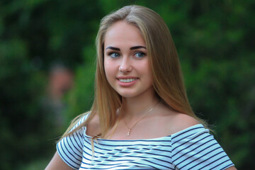 Naklejka premium beautiful fashionable blond girl in the city on the park in dress