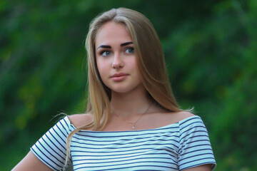 Fototapeta premium beautiful fashionable blond girl in the city on the park in dress
