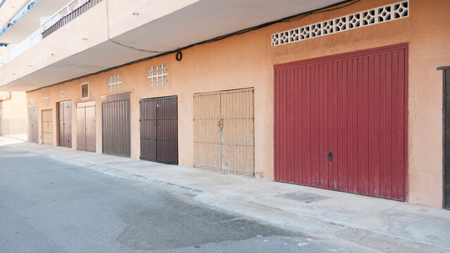 Puertas de garage marr&oacute;n y roja en calle de pueblo costero