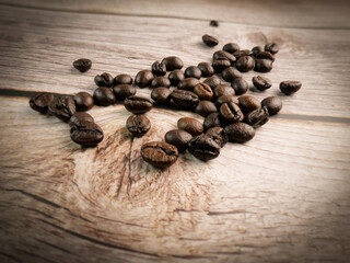 Close up shot of coffee beans was poured on the wooden floor focus at some point Gives a warm light to a warm mood insert a little darkness shooting in the studio