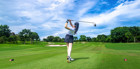 Professional woman golfer teeing golf in golf tournament competition at golf course for winner	
